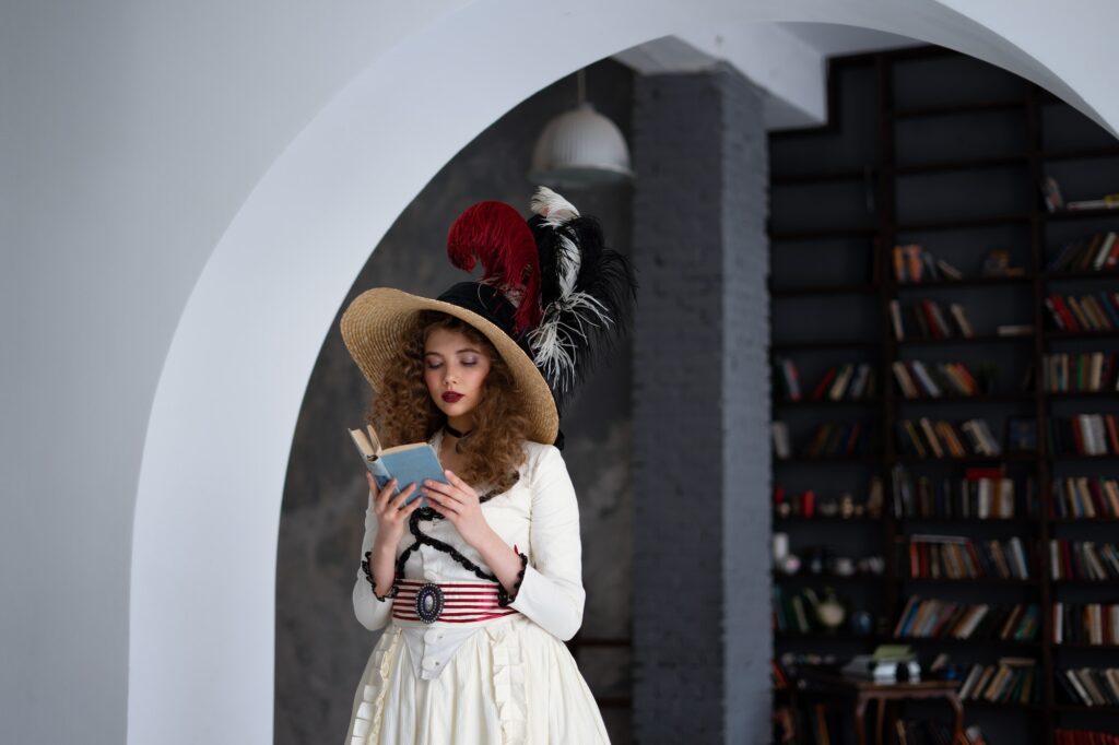 Books and reading. Beautiful young woman in retro outfit reading a book in the library